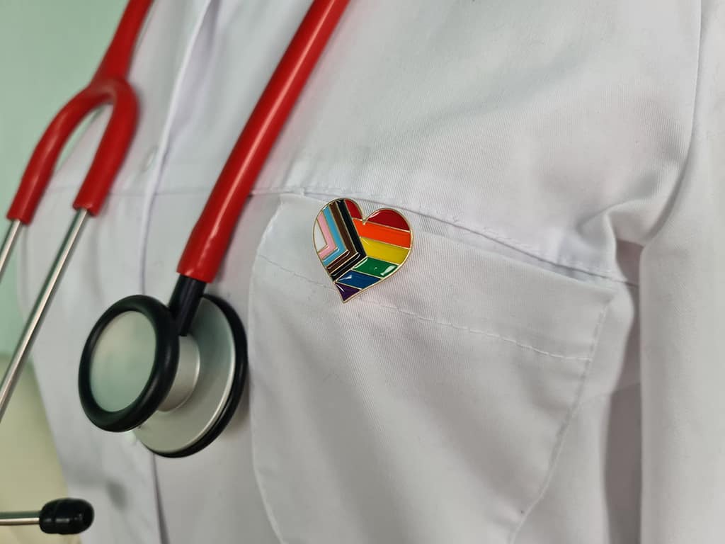 A provider wearing a rainbow heart pin
