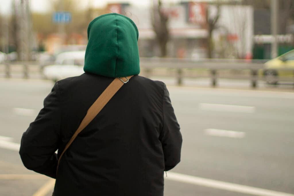 A young person in a hooded jacket on a city street