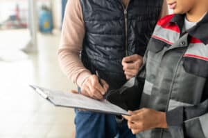 A person helping another fill our a form. This image is being used for PolicyWise for Children & Families' Building Youth Homelessness Data Collaboration project.